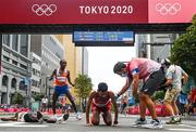 8 August 2021; Abdi Nageeye of Netherlands celebrates a second place finish as Ayad Lamdassem of Spain is treated by medical personnel after the men's marathon at Sapporo Odori Park on day 16 during the 2020 Tokyo Summer Olympic Games in Sapporo, Japan. Photo by Ramsey Cardy/Sportsfile