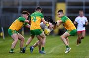 13 August 2021; Cormac Devlin of Tyrone is tackled by Donegal players, from left, Luke McGlynn, Karl Magee and Sean Martin during the Electric Ireland Ulster GAA Football Minor Championship Final match between Donegal and Tyrone at Brewster Park in Enniskillen, Fermanagh. Photo by Ben McShane/Sportsfile