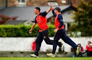 22 August 2021; Ryan MacBeth of Brigade, left, is congratulated by team-mate Adam McDaid after claiming the wicket of Cork Harlequins' Murtaza Sidiqi during the Clear Currency All-Ireland T20 Cup Final match between Cork Harlequins and Brigade at Leinster Cricket Club in Dublin. Photo by Seb Daly/Sportsfile