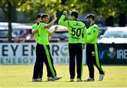 27 August 2021; Craig Young of Ireland, left, is congratulated by team-mates after claiming the wicket of Zimbabwe's Tadiwanashe Marumani during match one of the Dafanews T20 series between Ireland and Zimbabwe at Clontarf Cricket Club in Dublin. Photo by Seb Daly/Sportsfile