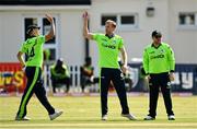 27 August 2021; Shane Getkate of Ireland, centre, is congratulated by team-mate Craig Young, left, after claiming the wicket of Zimbabwe's Dion Myers during match one of the Dafanews T20 series between Ireland and Zimbabwe at Clontarf Cricket Club in Dublin. Photo by Seb Daly/Sportsfile