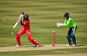 27 August 2021; Milton Shumba of Zimbabwe plays a shot, watched by Ireland wicketkeeper Neil Rock during match one of the Dafanews T20 series between Ireland and Zimbabwe at Clontarf Cricket Club in Dublin. Photo by Seb Daly/Sportsfile