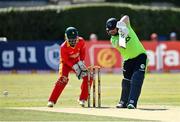 27 August 2021; Paul Stirling of Ireland plays a shot, watched by Zimbabwe wicketkeeper Regis Chakabva, during match one of the Dafanews T20 series between Ireland and Zimbabwe at Clontarf Cricket Club in Dublin. Photo by Seb Daly/Sportsfile