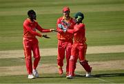 27 August 2021; Wellington Masakadza of Zimbabwe, left, celebrates with team-mates Craig Ervine, centre, and Regis Chakabva after taking the wicket of Ireland's Curtis Campher during match one of the Dafanews T20 series between Ireland and Zimbabwe at Clontarf Cricket Club in Dublin. Photo by Seb Daly/Sportsfile