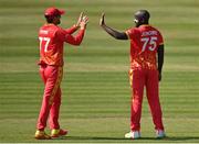 27 August 2021; Luke Jongwe of Zimbabwe is congratulated by team-mate Craig Ervine after taking the wicket of Ireland's Neil Rock during match one of the Dafanews T20 series between Ireland and Zimbabwe at Clontarf Cricket Club in Dublin. Photo by Seb Daly/Sportsfile