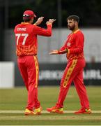 29 August 2021; Ryan Burl of Zimbabwe is congratulated by team-mate Craig Ervine after taking the wicket of Ireland's Andrew Balbirnie during match two of the Dafanews T20 series between Ireland and Zimbabwe at Clontarf Cricket Club in Dublin. Photo by Seb Daly/Sportsfile
