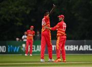 8 September 2021; Blessing Muzarabani of Zimbabwe, left, is congratulated by team-mate Craig Ervine after claiming the wicket of Ireland's Mark Adair during match one of the Dafanews International Cup ODI series between Ireland and Zimbabwe at Stormont in Belfast. Photo by Seb Daly/Sportsfile