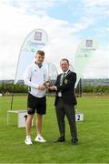 25 September 2021; Gerry McGuinness, President of the Community Games, makes a presentation to Irish 100 metre sprinter Marcus Lawler during the Aldi Community Games Track and Field Athletics finals at Carlow IT Sports Campus in Carlow. Photo by Matt Browne/Sportsfile