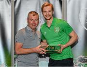 6 October 2021; Goalkeeper Caoimhin Kelleher is presented with his 2020-2021 Republic of Ireland international cap by former Republic of Ireland player Denis Irwin during a presentation at their team hotel in Dublin. Photo by Stephen McCarthy/Sportsfile