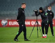 8 October 2021; Callum Robinson records footage of team-mates as manager Stephen Kenny walks by during a Republic of Ireland training session at the Olympic Stadium in Baku, Azerbaijan. Photo by Stephen McCarthy/Sportsfile