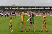 21 July 2013; A Donegal flag bearer leads Donegal players, from left, Michael Murphy, Paul Durcan, and Paddy McGrath, in the pre-match parade. Ulster GAA Football Senior Championship Final, Donegal v Monaghan, St Tiernach's Park, Clones, Co. Monaghan. Picture credit: Brian Lawless / SPORTSFILE