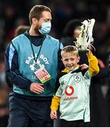 13 November 2021; A young Ireland supporter is escorted off the field with Conor Murray's boots after the Autumn Nations Series match between Ireland and New Zealand at Aviva Stadium in Dublin. Photo by Ramsey Cardy/Sportsfile