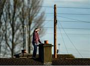 14 November 2021; A supporter watches on from a nearby rooftop during the Offaly County Senior Club Football Championship Final replay match between Rhode and Tullamore at Bord Na Móna O'Connor Park in Tullamore, Offaly. Photo by Harry Murphy/Sportsfile