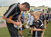 27 July 2013; Kildare footballer John Doyle and former Kilkenny hurler Martin Comerford supporting the Opel Kit for Clubs Blitz Day in St. Brigids GAA Club, Blanchardstown. Kildare footballer John Doyle autographs a football for Karl Nulty age 7, from St. Peregrines GAA Club, Clonsilla, Dublin. For every test drive, car service or Opel purchase made through the Opel dealer network, your local GAA club is awarded points. Build up your points and redeem them against high quality kit for your club! Log onto opelkitforclubs.com http://opelkitforclubs.com and start earning points today.  Support your local GAA club! St. Brigid's GAA Club, Blanchardstown, Dublin. Picture credit: Barry Cregg / SPORTSFILE