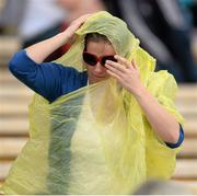 28 July 2013; A supporter attempts to shield from a shower of rain. GAA Hurling All-Ireland Senior Championship, Quarter-Final, Galway v Clare, Semple Stadium, Thurles, Co. Tipperary. Picture credit: Stephen McCarthy / SPORTSFILE
