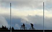 15 December 2021; Cyclists cycle past Munster Rugby squad training at the University of Limerick in Limerick. Photo by Brendan Moran/Sportsfile