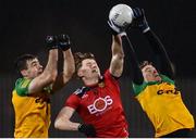 7 January 2022; Odhran Murdock of Down, centre, competes for the ball in the air against Caolan McGonigle, left, and Michael Langan of Donegal during the Dr McKenna Cup Round 1 match between Donegal and Down at Pairc MacCumhaill in Ballybofey, Donegal. Photo by Ramsey Cardy/Sportsfile
