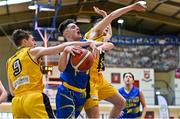 9 January 2022; Ronan Byrne of UCD Marian in action against Oisin Flynn and Sean O'Brien of Killorglin CYMS during the Basketball Ireland Men's U20 Cup semi-final match between UCD Marian and Killorglin CYMS at Neptune Stadium in Cork. Photo by Brendan Moran/Sportsfile