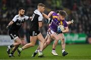 16 January 2022; Aaron Jones of Derrygonnelly Harps in action against Conor Laverty, left, and Jerome Johnston of Kilcoo during the AIB Ulster GAA Football Club Senior Championship Final match between Derrygonnelly Harps and Kilcoo at the Athletic Grounds in Armagh. Photo by Ramsey Cardy/Sportsfile
