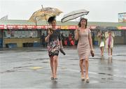 31 July 2013; Racegoers Lucy Hennessey, left, and Deirdre Hennessey, from Limerick, make their way to the stand in the rain. Galway Racing Festival, Ballybrit, Co. Galway. Picture credit: Barry Cregg / SPORTSFILE