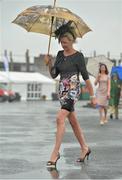 31 July 2013; Racegoer Lucy Hennessey, from Limerick, makes her way to the stand in the rain. Galway Racing Festival, Ballybrit, Co. Galway. Picture credit: Barry Cregg / SPORTSFILE