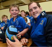 31 July 2013; Leinster's Devin Toner signs a ball for Luke McKenna, age 7, from the Curragh Camp, during a Leinster Rugby Summer Camp at Cill Dara RFC, Kildare, Co. Kildare. Picture credit: David Maher / SPORTSFILE