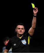 25 February 2022; Referee Robert Hennessy shows a yellow card during the SSE Airtricity League Premier Division match between Derry City and Shamrock Rovers at The Ryan McBride Brandywell Stadium in Derry. Photo by Stephen McCarthy/Sportsfile