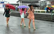 1 August 2013; Racegoers brave the wet weather conditions as they arrive ahead of the day's races. Galway Racing Festival, Ballybrit, Co. Galway. Picture credit: Barry Cregg / SPORTSFILE