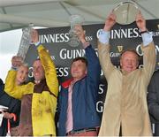 1 August 2013; Jockey Robbie Power, trainer Michael Winters, centre, and owner Dan Hutch lifts their respective trophies after victory in the Guinness Galway Hurdle Handicap with Missunited. Galway Racing Festival, Ballybrit, Co. Galway.