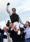 17 March 2022; Jockey Danny Mullins is lifted in celebration by winning connections of Flooring Porter, including Kerril Creaven, left, and James Skehill after winning the Paddy Power Stayers' Hurdle on day three of the Cheltenham Racing Festival at Prestbury Park in Cheltenham, England. Photo by Seb Daly/Sportsfile