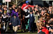 18 March 2022; Rachael Blackmore celebrates aboard A Plus Tard as they are led into the parade ring by groom John Ferguson after winning the Boodles Cheltenham Gold Cup Chase during day four of the Cheltenham Racing Festival at Prestbury Park in Cheltenham, England. Photo by Seb Daly/Sportsfile