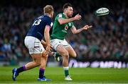19 March 2022; Hugo Keenan of Ireland passes despite the attention of Chris Harris of Scotland during the Guinness Six Nations Rugby Championship match between Ireland and Scotland at Aviva Stadium in Dublin. Photo by Brendan Moran/Sportsfile