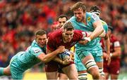 16 April 2022; Chris Farrell of Munster is tackled by Joe Simmons and Jonny Gray of Exeter Chiefs during the Heineken Champions Cup Round of 16 Second Leg match between Munster and Exeter Chiefs at Thomond Park in Limerick. Photo by Harry Murphy/Sportsfile