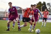 18 April 2022; Matty Smith of Derry City in action against Andrew Quinn, left, and Dylan Grimes of Drogheda United during the SSE Airtricity League Premier Division match between Drogheda United and Derry City at Head in the Game Park in Drogheda, Louth. Photo by Ben McShane/Sportsfile