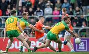 24 April 2022; Aidan Nugent of Armagh shoots at goal under pressure from Donegal players, from left, Ciaran Thompson, Stephen McMenamin and Hugh McFadden during the Ulster GAA Football Senior Championship Quarter-Final match between Donegal and Armagh at Páirc MacCumhaill in Ballybofey, Donegal. Photo by Ramsey Cardy/Sportsfile