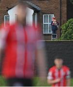 9 May 2022; A Derry City supporter watches on with her dog, from outside the ground, during the SSE Airtricity League Premier Division match between Derry City and St Patrick's Athletic at The Ryan McBride Brandywell Stadium in Derry. Photo by Ramsey Cardy/Sportsfile
