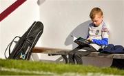 14 May 2022; Ollie Flynn, aged 8, son of Westmeath coach Richie Flynn, reads his programme in the dugout ahead of the Leinster GAA Hurling Senior Championship Round 4 match between Westmeath and Wexford at TEG Cusack Park in Mullingar, Westmeath. Photo by Daire Brennan/Sportsfile