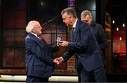 20 May 2022; President of Ireland Michael D Higgins presents former Republic of Ireland international David O’Leary with an FAI centenary medal during the FAI Centenary Late Late Show Special at RTE Studios in Dublin. Photo by Stephen McCarthy/Sportsfile