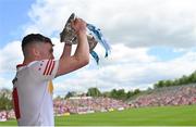 29 May 2022; Eoin McElholm of Tyrone lifts the trophy after his side's victory in the Electric Ireland Ulster GAA Football Minor Championship Final match between Derry and Tyrone at St Tiernach's Park in Clones, Monaghan. Photo by Ramsey Cardy/Sportsfile