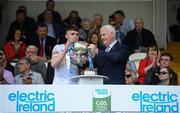29 May 2022; Tyrone captain Eoin McElholm is presented with the Fr Murray Cup by Ulster GAA vice-president Michael Geoghegan after the Electric Ireland Ulster GAA Football Minor Championship Final match between Derry and Tyrone at St Tiernach's Park in Clones, Monaghan. Photo by Stephen McCarthy/Sportsfile