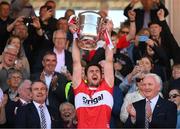 29 May 2022; Derry captain Christopher McKaigue lifts the Anglo Celt Cup alongside Ulster GAA president Ciaran McLaughlin, left, and Ulster GAA vice-president Michael Geoghegan, right, during the Ulster GAA Football Senior Championship Final between Derry and Donegal at St Tiernach's Park in Clones, Monaghan. Photo by Stephen McCarthy/Sportsfile