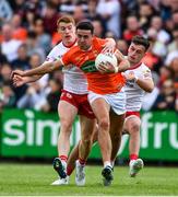 5 June 2022; Stefan Campbell of Armagh is tackled by Peter Harte, left, and Michael McKernan of Tyrone during the GAA Football All-Ireland Senior Championship Round 1 match between Armagh and Tyrone at Athletic Grounds in Armagh. Photo by Ben McShane/Sportsfile