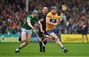 5 June 2022; Tony Kelly of Clare scores a point despte the efforts of William O'Donoghue of Limerick during the Munster GAA Hurling Senior Championship Final match between Limerick and Clare at FBD Semple Stadium in Thurles, Tipperary. Photo by Brendan Moran/Sportsfile