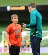 7 June 2022; 12-year-old Ukrainian citizen Mattvii Rybkin, from Zhytomyr, reacts as Republic of Ireland's Seamus Coleman tells him he is going to video call his Everton club-mate Vitaliy Mykolenko to speak to Mattvii, who was invited to watch a Republic of Ireland training session at Aviva Stadium in Dublin. Photo by Stephen McCarthy/Sportsfile