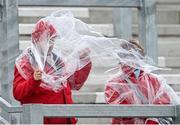 11 June 2022; Cork supporters take shelter from the rain before the GAA Hurling All-Ireland Senior Championship Preliminary Quarter-Final match between Antrim and Cork at Corrigan Park in Belfast. Photo by Ramsey Cardy/Sportsfile