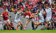 12 June 2022; Cathail O’Mahony of Cork is tackled by Iain Corbett, left, and Sean O'Dea of Limerick during the GAA Football All-Ireland Senior Championship Round 2 match between between Cork and Limerick at Páirc Ui Chaoimh in Cork. Photo by Eóin Noonan/Sportsfile