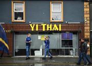 5 June 2022; Supporters shelter from the rain in the town centre before the Munster GAA Hurling Senior Championship Final match between Limerick and Clare at FBD Semple Stadium in Thurles, Tipperary. Photo by Brendan Moran/Sportsfile