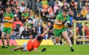 12 June 2022; Patrick McBrearty of Donegal evades the tackle of Armagh's Stephen Sheridan during the GAA Football All-Ireland Senior Championship Round 2 match between between Donegal and Armagh at St Tiernach's Park in Clones, Monaghan. Photo by Seb Daly/Sportsfile