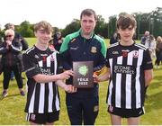 25 June 2022; Assistant Secretary of the Meath County Board Brian Kelly presents the Division 4 Shield trophy to Middletown Na Fianna, Armagh, captains Daithí Barret, left, and Darragh McKenna during the John West Féile na nGael National Camogie and Hurling Finals at Boardsmill GAA Club in Meath. Photo by Daire Brennan/Sportsfile