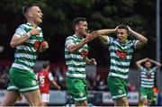 27 June 2022; Aaron Greene of Shamrock Rovers, centre, celebrates towards the St Patrick's Athletic supporters after scoring his side's second goal with team mates Andy Lyons, left, and Gary O'Neill reacting during the SSE Airtricity League Premier Division match between St Patrick's Athletic and Shamrock Rovers at Richmond Park in Dublin. Photo by George Tewkesbury/Sportsfile